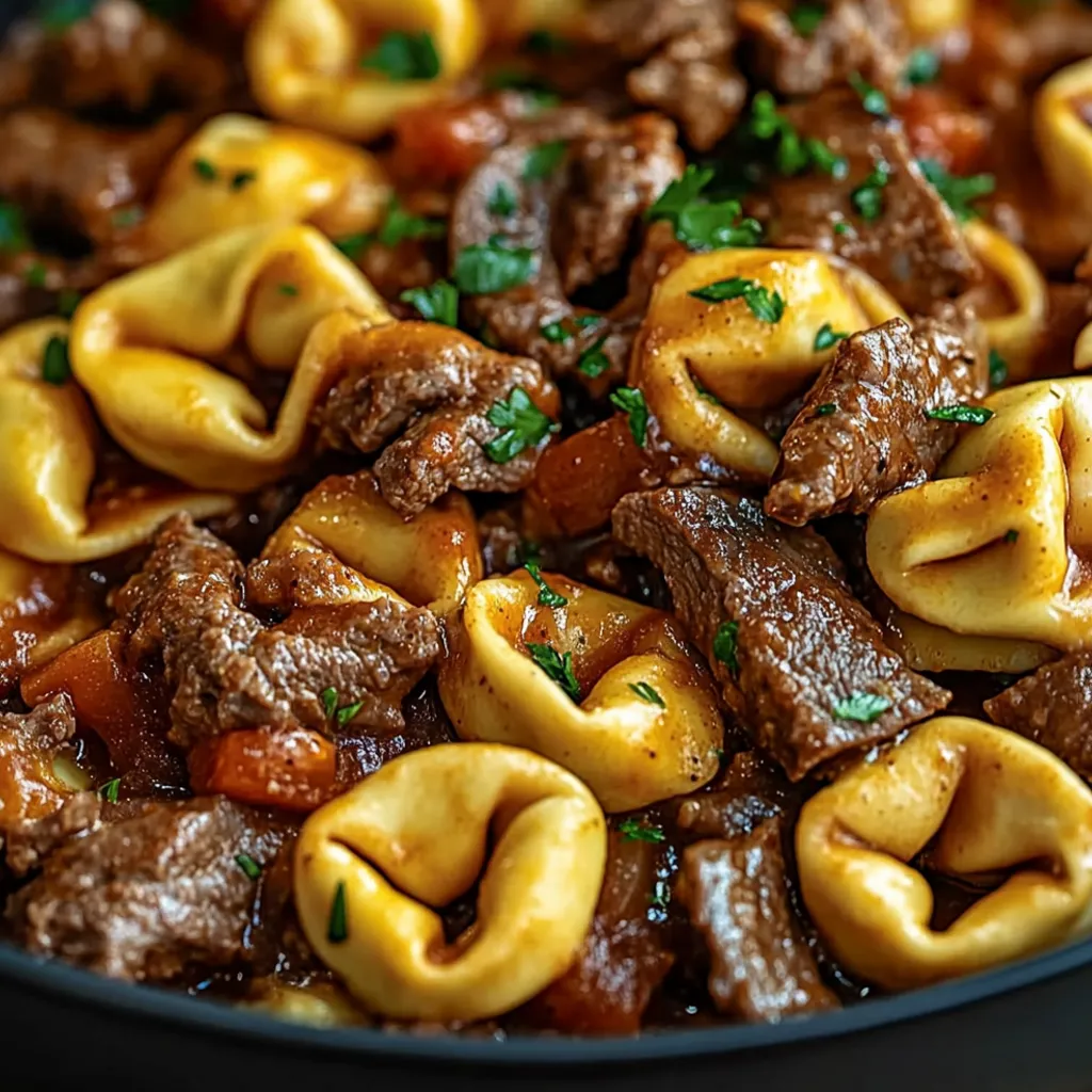 A bowl of pasta with meat and cheese.