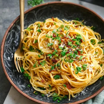 A bowl of noodles with garlic and herbs.