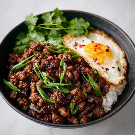 A bowl of crispy beef and rice.