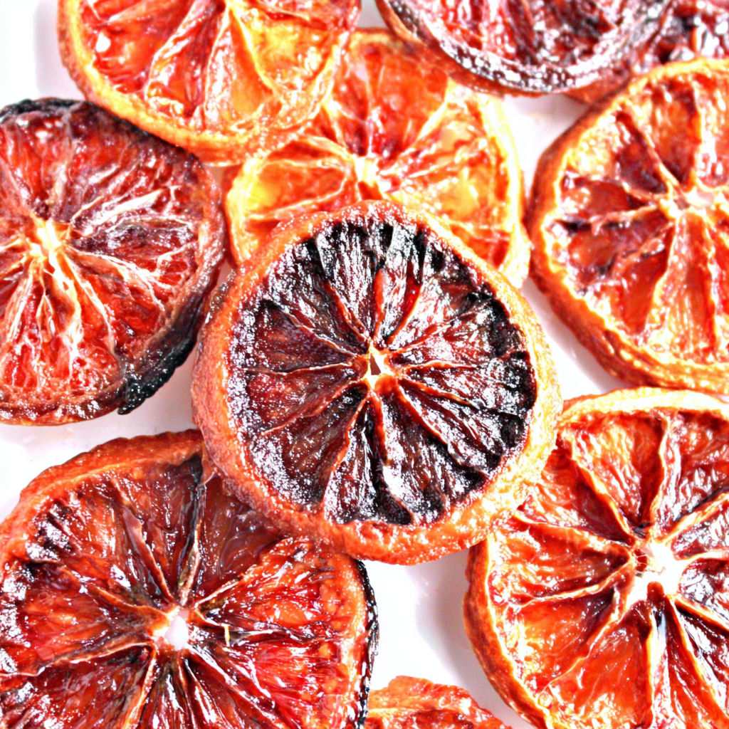 A close up of a sliced orange with a burnt edge.