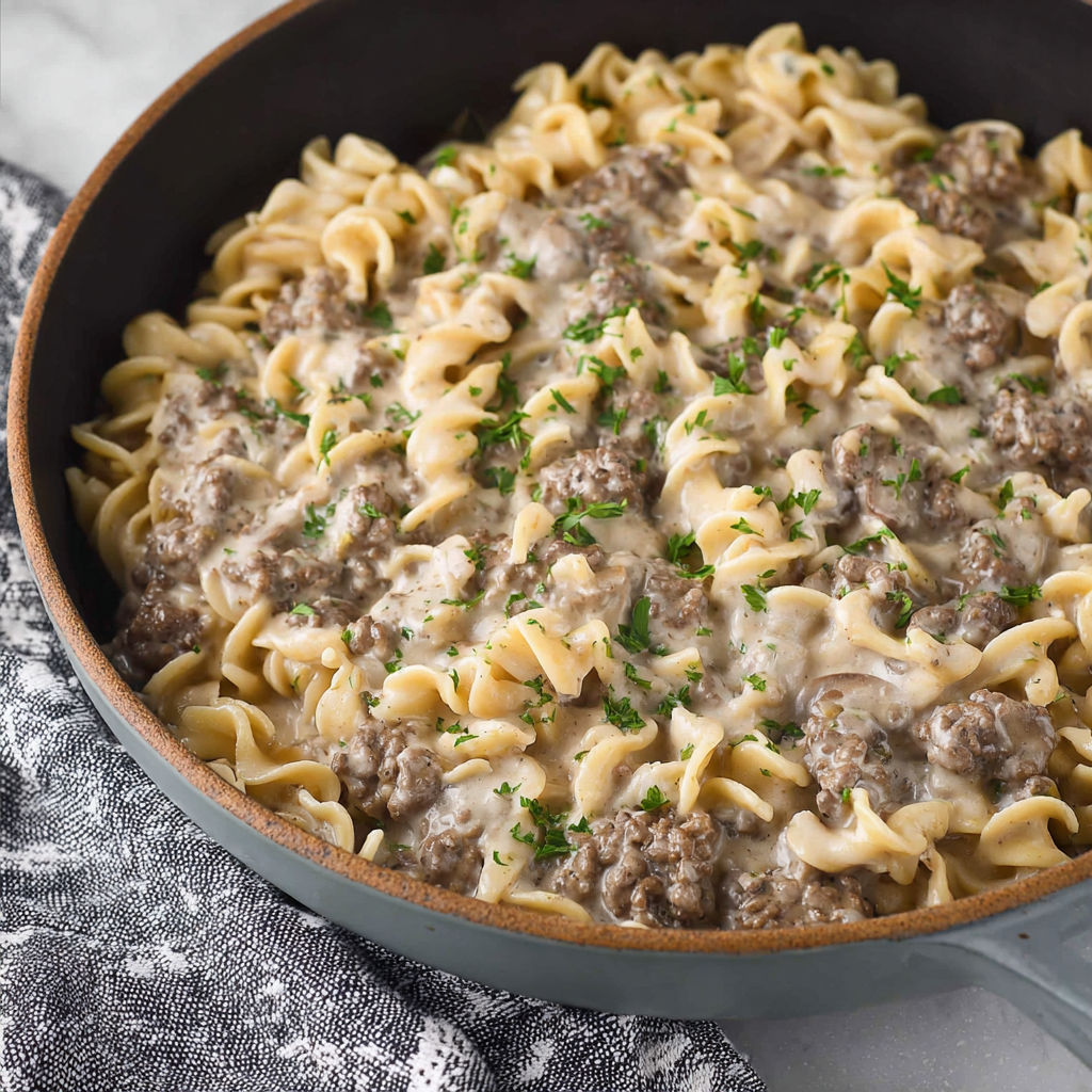 A bowl of pasta with meat and cheese.