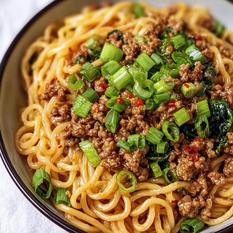 A bowl of noodles with meat and vegetables.