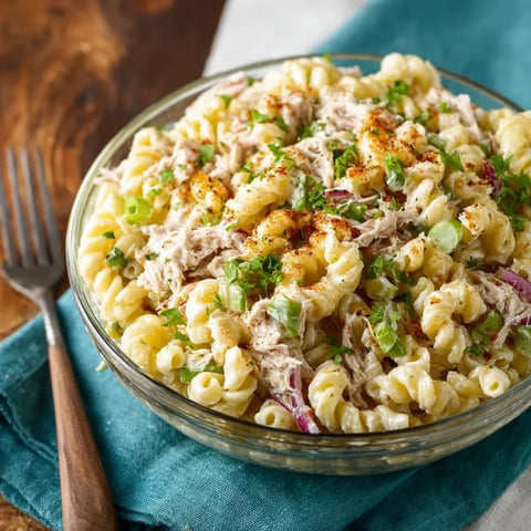 A bowl of macaroni salad with tuna.
