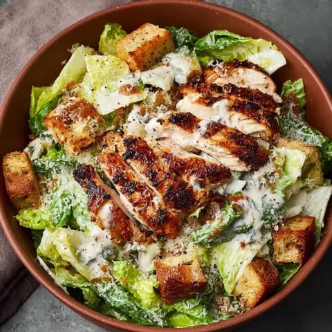 A bowl of chicken Caesar salad.