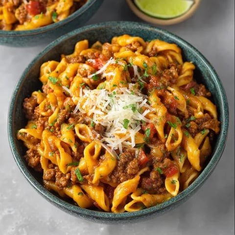 A bowl of pasta with meat and cheese.
