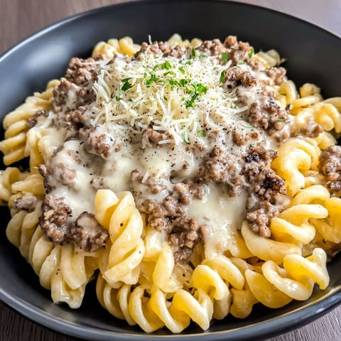 A bowl of pasta with meat and cheese.
