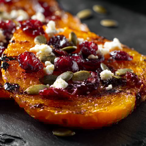 A slice of honey roasted butternut squash with cranberries, feta, and pumpkin seeds.