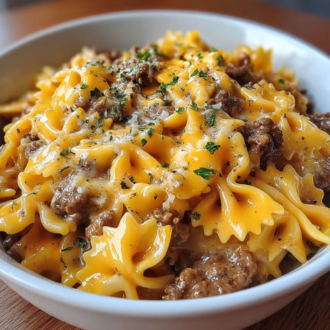 A bowl of pasta with cheese and meat.