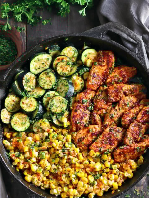 A delicious one-pan meal of garlic butter chicken, zucchini, and corn.
