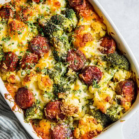 A dish of broccoli, cauliflower, cheese, and sausage.